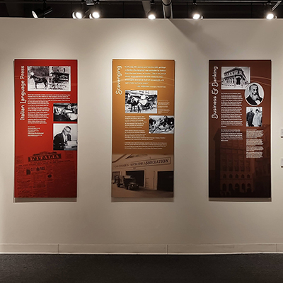 This wall is divided into three panels. The first panel from the left is red and covers the Italian press. The second panel, in yellow, covers scavenging. The third panel on the right is dark brown and covers the topics of business and banking.