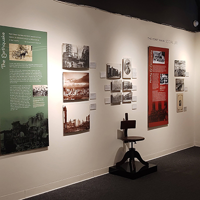 This wall features a green panel dedicated to the earthquakes on the left side, followed by a sequence of multiple black and white images. Adjacent to these images, there is also a red panel dedicated to the community.