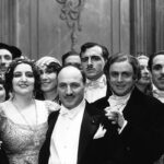 A black and white image from the opera La Traviata in 1932. The picture features a large group of opera singers, including the famous Claudia Muzio and opera director Gaetano Merola. They are all beautifully dressed, and the picture was taken at the end of the show.