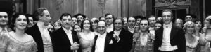 A black and white image from the opera La Traviata in 1932. The picture features a large group of opera singers, including the famous Claudia Muzio and opera director Gaetano Merola. They are all beautifully dressed, and the picture was taken at the end of the show.