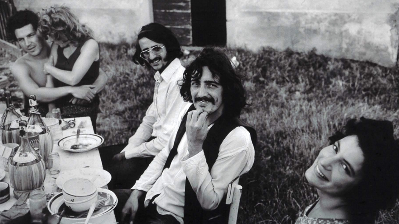 Imagine black and white from the '70s. There are three people, two men and one woman, sitting in a garden. On the right side, there is information regarding the event. Starting with the logo on the top, followed by the title "A Journey Back" with the date August 8, 2024.