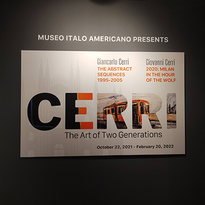 The title wall is dark gray with a white panel for the exhibition. The panel features the name "CERRI" with two images embedded in the font. At the top, it displays the names of the artists: "Giancarlo Cerri e Giovanni Cerri" with a single title. Below the title, there is a subtitle: "The Art of Two Generations."