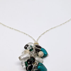 A necklace with white, clear, and peacock colored beads, in a variety of shapes, forming a pendant.