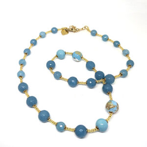 A string necklace with blue-hued glass beads with gold spacer beads.