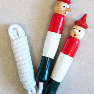 A jumping rope with painted red, white, and green wooden handles, each featuring a smiling Pinocchio head.