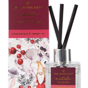 A maroon box with a design featuring holiday-inspired watercolor foliage and a small gnome, alongside a small diffuser with black reeds.