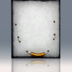 A necklace featuring a central orange handblown glass bead, with smaller beads as accents.