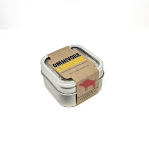 A small, metallic tin of salt, wrapped in a brown paper sleeve with "OMNIVORE LIMONE".