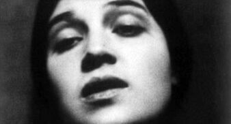 A grainy black and white photograph of a woman's face in a sultry expression.