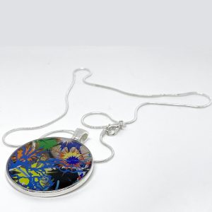 This necklace has a center circular pendant that reflects one of Kara Maria’s paintings—an abstract splash of multiple colors with a small butterfly in the middle.