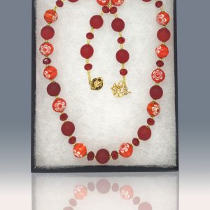 Necklace with blood red frosted beads, red crystal and delicate red and orange striped beads, each with a millefiore flowers separated by tiny golden glass beads.